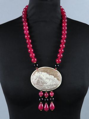 une femme portant un collier orné d'une pièce de monnaie et de perles rouges
