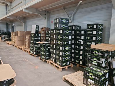 de nombreuses caisses de bière sur des palettes dans un entrepôt
