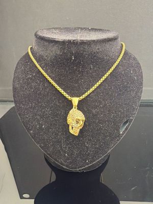 a close up of a necklace on a mannequin with a skull on it