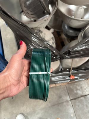 une personne tenant une bobine verte à la main