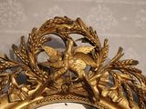 a gold clock with a bird on top of it