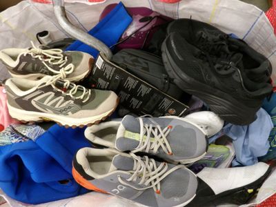 many pairs of shoes in a basket on the floor