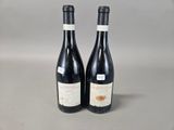 two bottles of wine sitting on top of a table next to each other