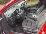 a red car with a black seat in the back of it