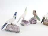cinq figurines d'oiseaux perchés sur un rocher