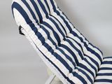 a white chair with a blue and white striped cushion on it