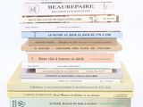 several books stacked on top of each other on a white surface