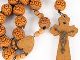 rosary with wooden beads and a wooden cross on a white background