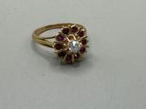 gros plan d'une bague en or avec des pierres rouges et blanches