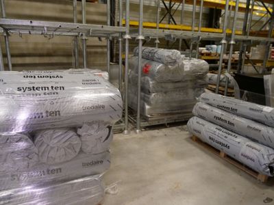many rolls of paper sitting on a pallet in a warehouse
