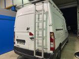 a white van parked in a garage with a ladder on the back