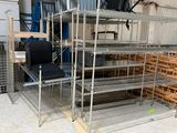 une étagère métallique comportant plusieurs tablettes et des chaises