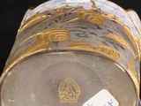 a gold and white vase sitting on top of a clear box