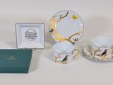 three cups and saucers and a box on the table