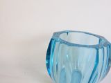 a blue glass vase that is sitting on a table