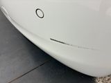 a close up of a white car with a hole in the side