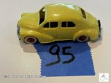 une petite voiture jaune posée sur une feuille de papier bleue