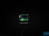 une tourmaline verte posée sur un fond noir
