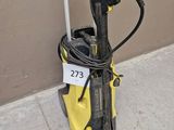 une borne électrique jaune et noire posée au sol près d'un mur