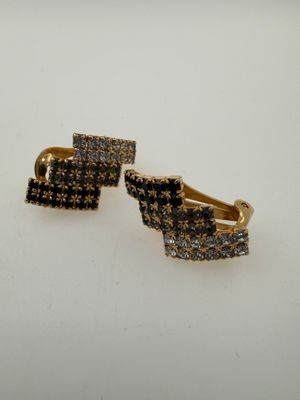 a pair of black and white diamond earrings on a white surface