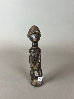 une petite figurine en bois coiffée d'un casque
