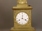 une horloge en or surmontée d'un buste d'homme