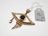 une image représentant un collier plaqué or orné d'un œil en pierre noire
