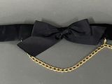 black belt with a gold chain and a black bow on it