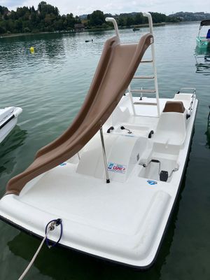 a boat with a slide on the back of it in the water