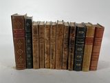 plusieurs vieux livres sont alignés sur une surface blanche