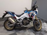 une moto blanche et bleue garée sur un sol à damier
