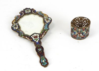 une image représentant un petit miroir et une bague sur une surface blanche