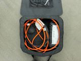 a person standing next to an open suitcase with wires in it