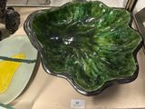 a green leaf shaped bowl sitting on a counter