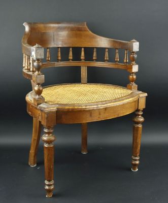 une image représentant une chaise en bois avec une assise en osier sur fond noir