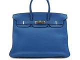 a blue leather handbag on a white background