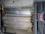 a lot of steel bars that are stacked up in a garage