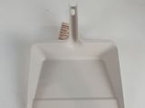 a white dust pan on a white counter top
