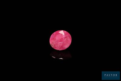 a close up of a pink diamond on a black surface