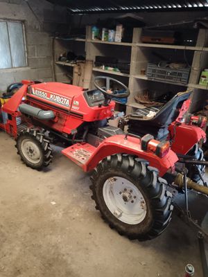 a red tractor that is parked in a garage