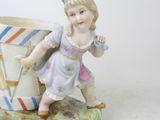 a figurine of a little girl holding a cup