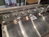 stainless steel counter top with six pans and a price tag on it