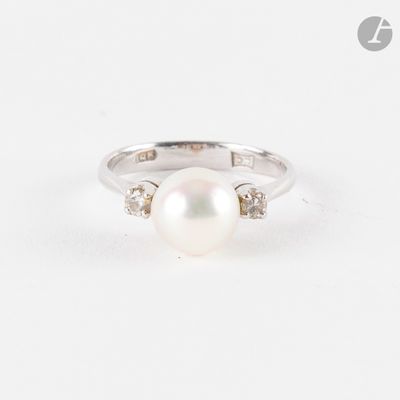 gros plan d'une bague en perles et diamants sur une surface blanche