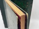 an open book sitting on top of a table next to a pile of books