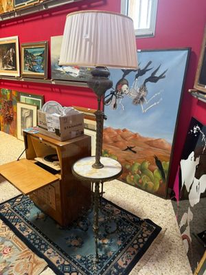 a lamp that is sitting on a table in front of a painting