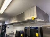 une cuisine équipée d'appareils électroménagers en acier inoxydable et d'une hotte aspirante