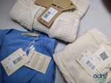 three sweaters are on a table with price tags on them