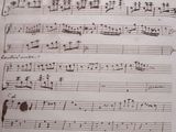 an old manuscript with music notes on it sitting on a table