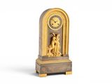 une horloge posée sur un support sur une surface blanche