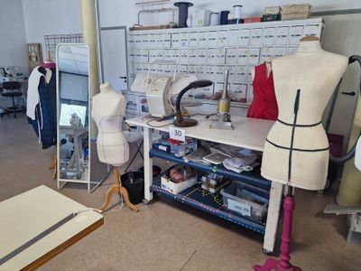 une photo d'un atelier de couture avec des mannequins et des machines à coudre